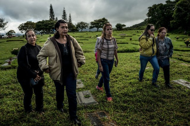 A la izquierda, Aura Pérez, tía de Óscar Pérez, caminando hacia el sitio del entierro. Ella recibió el cuerpo de la morgue porque es la familiar más cercana que todavía permanece en Venezuela. Credit Meridith Kohut para The New York Times