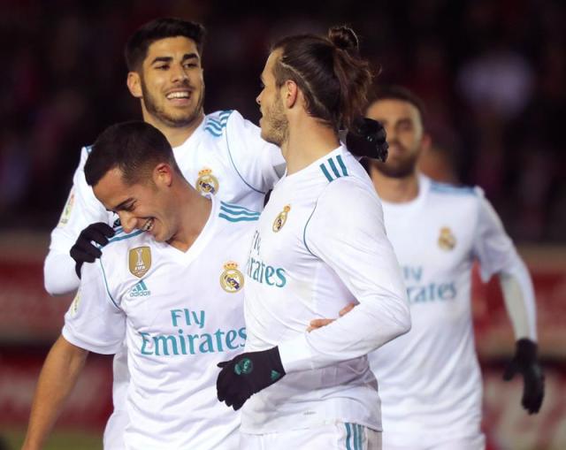 El centrocampista galés del Real Madrid Gareth Bale (d) celebra con sus compañeros Marco Asensio (detrás) y Lucas Vázquez el primer gol ante el Numancia en partido de ida de octavos de final de la Copa del Rey que se disputa en el estadio de los Pajaritos de Soria. EFE/ Wifredo García