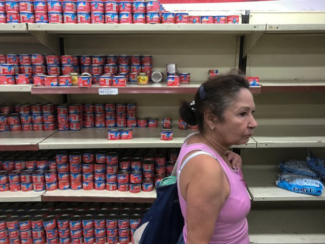 Una mujer busca comestibles y productos en un supermercado en Caracas, Venezuela, el 6 de enero de 2018. REUTERS / Marco Bello