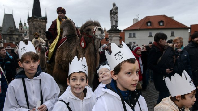 Boys walk during a procession marking the Three Kings' journey to Jesus born in Bethlehem, in Prague on January 5, 2018.  / AFP PHOTO / Michal CIZEK