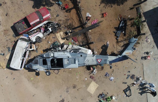 Aerial view of the military helicopter that fell on a van in Santiago Jamiltepec, Oaxaca state, Mexico, on February 17, 2018. A 7.2-magnitude earthquake rattled Mexico on Friday, causing little damage but triggering a tragedy when a minister's helicopter crash-landed on the way to the epicenter, Oaxaca, killing thirteen people, including three children, on the ground. / AFP PHOTO / MARIO VAZQUEZ