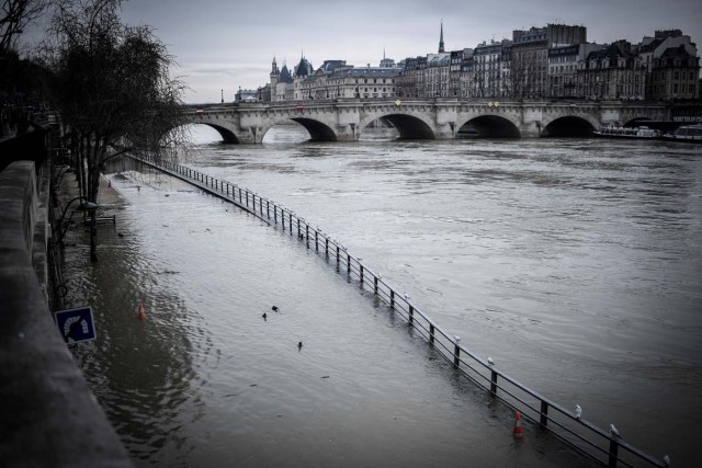 Flood waters from the Seine river flow onto a road in central Paris on February 19, 2018. / AFP PHOTO / STEPHANE DE SAKUTIN