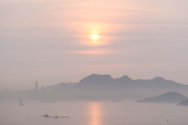 This general view shows the sun rising in Hong Kong early on February 20, 2018. / AFP PHOTO / Anthony WALLACE