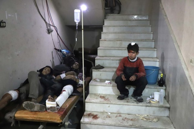 Wounded Syrians wait to receive treatment at a make-shift hospital in Kafr Batna in the besieged Eastern Ghouta region on the outskirts of the capital Damascus following Syrian government bombardments on February 21, 2018. Syrian jets carried out more deadly raids on Eastern Ghouta as Western powers and aid agencies voiced alarm over the mounting death toll and spiralling humanitarian catastrophe. / AFP PHOTO / Amer ALMOHIBANY