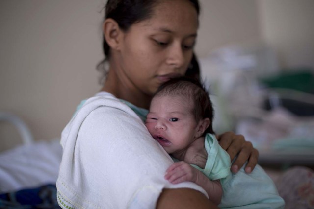 Venezuelan national Dayana Rodriguez, 17, cuddles her newborn daughter Sofia, 12 days, at the Maternity Hospital Nossa Senhora de Nazare in the city of Boa Vista, Roraima, Brazil, on February 26, 2018. Of every 4 births in Boa Vista's maternity hospital one is from a Venezuelan mother. According to local authorities around one thousand refugees are crossing each day the Brazilian border from Venezuela. The constant flux of Venezuela's immigrants are living in shelters and streets of Boa Vista and Pacaraima cities. They are crossing to Brazil looking for work, medical care and food. Boa Vista's three hundred thousand population includes a 10 percent of Venezuelans. / AFP PHOTO / MAURO PIMENTEL