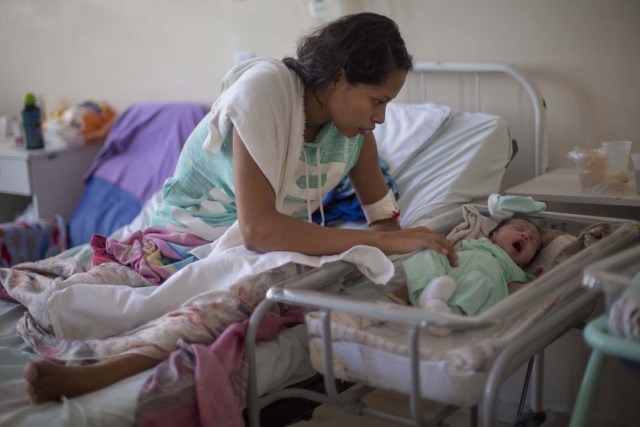 Venezuelan refugee Dayana Rodriguez, 17, takes care of her newborn daughter Sofia, 12 days, at the Maternity Hospital Nossa Senhora de Nazare in the city of Boa Vista, Roraima, Brazil, on February 26, 2018. Of every 4 births in Boa Vista's maternity hospital one is from a Venezuelan mother. According to local authorities around one thousand refugees are crossing each day the Brazilian border from Venezuela. The constant flux of Venezuela's immigrants are living in shelters and streets of Boa Vista and Pacaraima cities. They are crossing to Brazil looking for work, medical care and food. Boa Vista's three hundred thousand population includes a 10 percent of Venezuelans. / AFP PHOTO / MAURO PIMENTEL