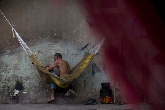 A Venezuelan refugee takes a rest on a hammock, at a shelter in the city of Boa Vista, Roraima, Brazil, on February 24, 2018. When the Venezuelan migratory flow exploded in 2017 the city of Boa Vista, the capital of Roraima, 200 kilometres from the Venezuelan border, began to organise shelters as people started to settle in squares, parks and corners of this city of 330,000 inhabitants of which 10 percent is now Venezuelan. / AFP PHOTO / MAURO PIMENTEL