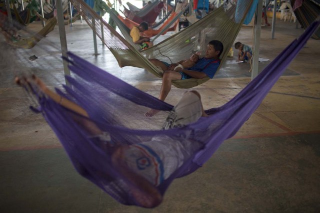 Venezuelan indigenous refugees rest on their hammocks, at a shelter in the city of Boa Vista, Roraima, Brazil, on February 24, 2018. When the Venezuelan migratory flow exploded in 2017 the city of Boa Vista, the capital of Roraima, 200 kilometres from the Venezuelan border, began to organise shelters as people started to settle in squares, parks and corners of this city of 330,000 inhabitants of which 10 percent is now Venezuelan. / AFP PHOTO / MAURO PIMENTEL