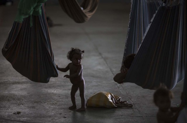 A Venezuelan indigenous refugee child is pictured inside a shelter in the city of Boa Vista, Roraima, Brazil, on February 24, 2018. When the Venezuelan migratory flow exploded in 2017 the city of Boa Vista, the capital of Roraima, 200 kilometres from the Venezuelan border, began to organise shelters as people started to settle in squares, parks and corners of this city of 330,000 inhabitants of which 10 percent is now Venezuelan. / AFP PHOTO / MAURO PIMENTEL