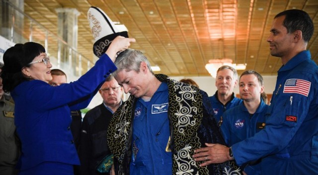 El astronauta estadounidense Mark Vande Hei (C) de la NASA recibe un sombrero kazajo tradicional después de una conferencia de prensa en Dzhezkazgan el 28 de febrero de 2018. / AFP PHOTO / POOL / Alexander NEMENOV