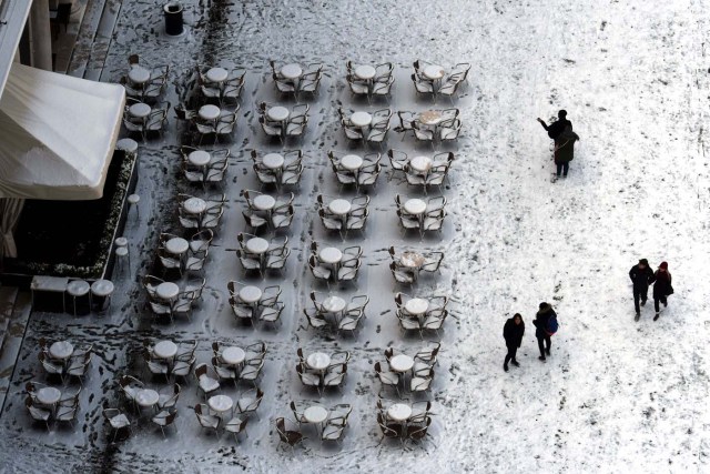 Aerial view of people walking on the snow-covered St Mark's square in Venice on February 28, 2018 after a overnigth snowfall. / AFP PHOTO / Andrea PATTARO