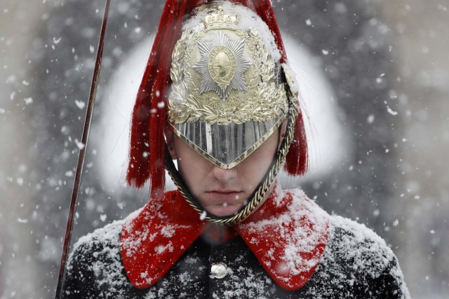 Snow falls on a member of the Household Cavalry Mounted Regiment, on Whitehall in central London on on February 28, 2018. Europe remained Wednesday gripped by a blast of Siberian weather which has killed at least 24 people and carpeted palm-lined Mediterranean beaches in snow. / AFP PHOTO / Tolga AKMEN