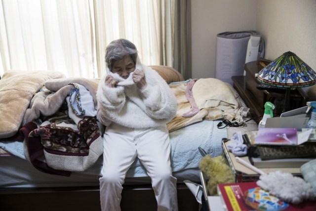 In this picture taken on January 16, 2018, Kimiko Nishimoto gets dressed to prepare for a photoshoot at her house in the western Japanese city of Kumamoto. The madcap Japanese great-grandmother armed with a camera and an appetite for mischief has shot to fame for taking side-splitting selfies -- many of which appear to put her in harm's way. / AFP PHOTO / Behrouz MEHRI / TO GO WITH Japan-lifestyle-photography-offbeat-senior-citizens,FEATURE by Alistair HIMMER