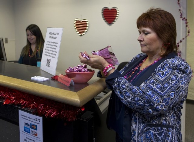 Paula Cook with the Clark County Clerk's Office refills a candy dish as she helps operates a temporary pop-up marriage license office at McCarran International Airport in Las Vegas on February 12, 2018. The Las Vegas airport has given new meaning to rushing to make a connection, offering quickie wedding licenses for lovebirds desperate to get hitched on Valentine's Day. Clark County, the authority that administers Sin City's weddings, has opened a pop-up marriage license bureau by a baggage carousel at McCarran International Airport. / AFP PHOTO / L.E. Baskow / TO GO WITH AFP STORY, "Valentines get quickie marriage licenses at Las Vegas airport"