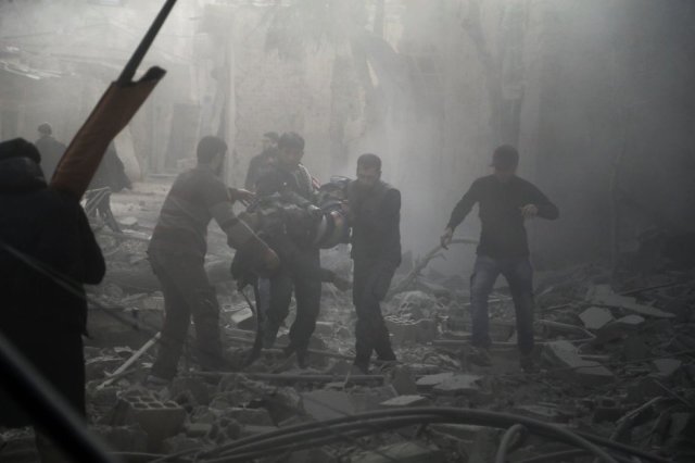 Al menos 15.000 vecinos han sido de nuevo desplazados de sus hogares huyendo de la artillería siria que este lunes han lanzado 260 morteros en el intervalo de dos horas, según el recuento que hace el Observatorio Sirio de Derechos Humanos. En la imagen, dos personas buscan víctimas entre los escombros en Hamouria, en Guta oriental, el 20 de febrero de 2018. (Foto: ABDULMONAM EASSA / AFP)
