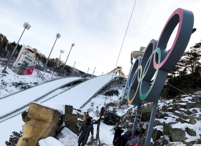 Workers install Olympic Rings at the Alpensia Ski Jumping Centre in Pyeongchang, South Korea, January 25, 2018. REUTERS/Pawel Kopczynski