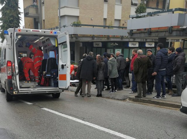 People look at healthcare personnel taking care of an injured person after being shot by gunfire from a vehicle, in Macerata, Italy, February 3, 2018. REUTERS/Stringer NO RESALES NO ARCHIVE