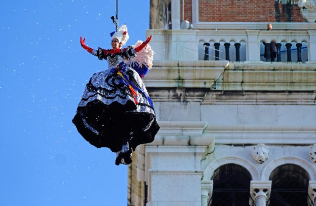 A woman dressed as an "angel" descends on Saint Mark's Square during the Venice Carnival, Italy, February 4, 2018. REUTERS/Manuel Silvestri