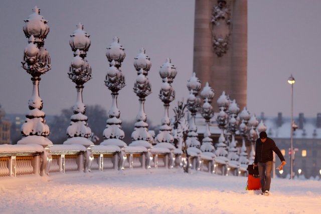 Un hombre camina sobre el puente cubierto de nieve de Pont Alexandre III temprano en la mañana en París, mientras el clima invernal con nieve y temperaturas heladas llegan a Francia el 7 de febrero de 2018. REUTERS / Gonzalo Fuentes