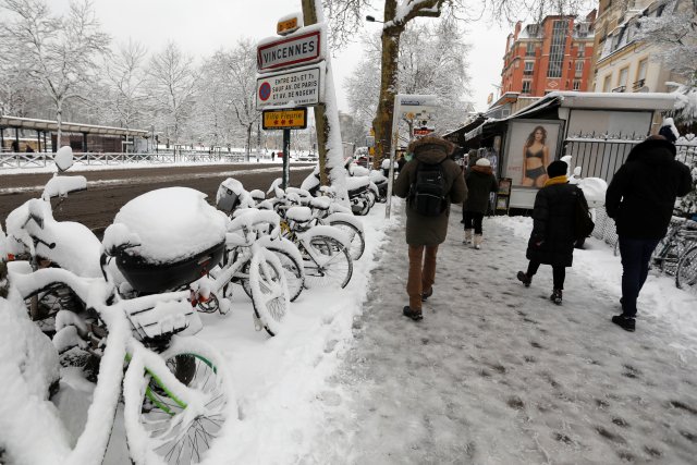 Los viajeros caminan por un sendero cubierto de nieve cerca de la estación de metro Chateau de Vincennes, cerca de París, Francia, mientras el clima invernal con nieve y temperaturas bajo cero llegan a Francia el 7 de febrero de 2018. REUTERS / Charles Platiau