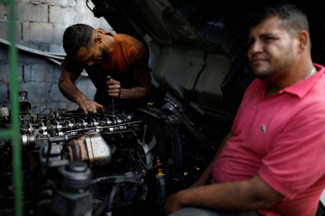 Mechanics repair a truck used to transport vegetables in a workshop in La Grita, Venezuela January 27, 2018. The truck hasn't been operational for more than six months as the owner has not been able to find the necessary spare parts. REUTERS/Carlos Garcia Rawlins SEARCH "LAWLESS ROADS" FOR THIS STORY. SEARCH "WIDER IMAGE" FOR ALL STORIES.?