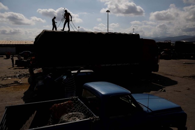 Trabajadores atan una carga de verduras a un camión en el mercado mayorista de Barquisimeto, Venezuela el 30 de enero de 2018. REUTERS / Carlos Garcia Rawlins