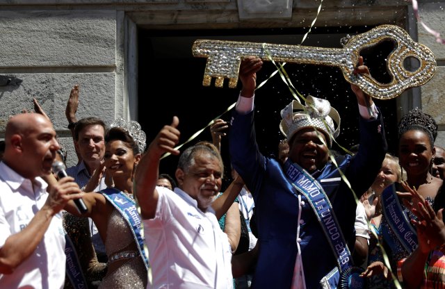 En Rio de Janeiro's Mayor Marcelo Crivella (2nd L) observes as the Rei Momo, or Carnival King, Milton Junior holds up the key of the city during a ceremony at Cidade Palace in Rio de Janeiro, Brazil February 9, 2018. REUTERS/Ricardo Moraes