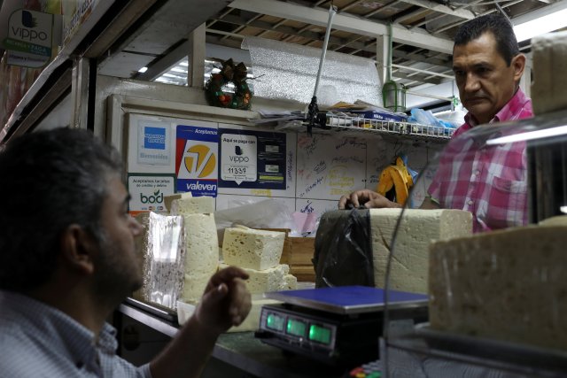 Information for Vippo app and other methods of payment is seen at a cheese and dairy products stall at Chacao Municipal Market in Caracas, Venezuela January 19, 2018. Picture taken January 19, 2018. REUTERS/Marco Bello