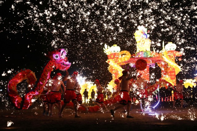 Folk artists perform a fire dragon dance under a shower of sparks from molten iron, ahead of the Chinese Lunar New Year, in Shangqiu, Henan province, China February 14, 2018. Picture taken February 14, 2018. REUTERS/Stringer ATTENTION EDITORS - THIS IMAGE WAS PROVIDED BY A THIRD PARTY. CHINA OUT.