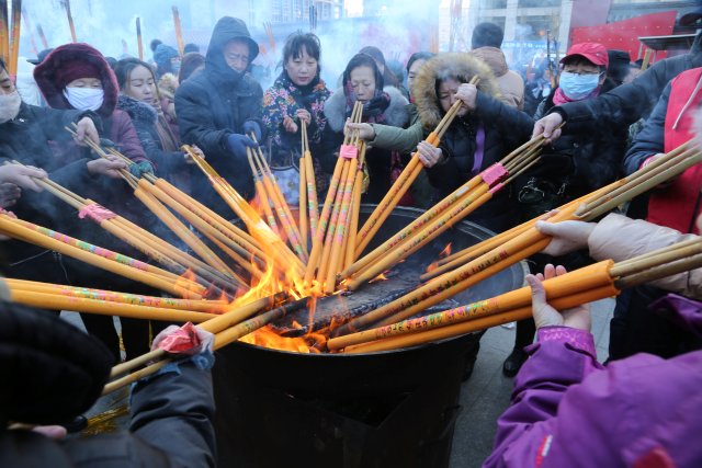 People burn incense sticks and pray for good fortune at the Shisheng Temple on the first day of the Chinese Lunar New Year of Dog, in Shenyang, Liaoning province, China, February 16, 2018. REUTERS/Stringer ATTENTION EDITORS - THIS IMAGE WAS PROVIDED BY A THIRD PARTY. CHINA OUT.