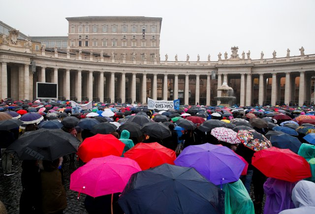 La gente está cubierta con paraguas mientras el Papa Francisco dirige su oración dominical del Ángelus en la plaza de San Pedro en el Vaticano el 18 de febrero de 2018. REUTERS / Tony Gentile