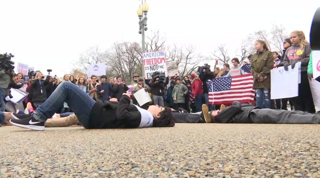 Demonstrators lay on the ground at a rally for gun control outside of the White House in Washington, DC, U.S. February 19, 2018 in this still image from video. REUTERS TV/ via REUTERS