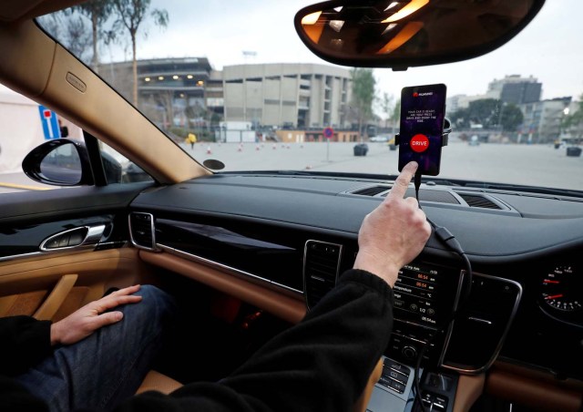 An engineer points to a Huawei Mate 10 Pro mobile used to control a driverless car during the Mobile World Congress in Barcelona, Spain February 26, 2018. REUTERS/Yves Herman