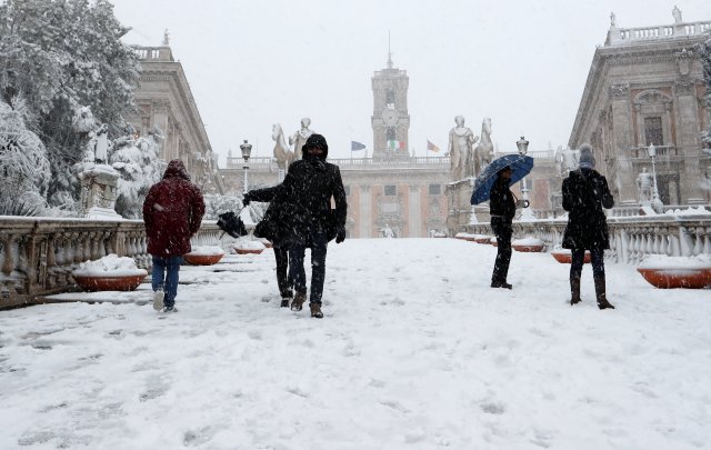La gente camina en el palacio de Campidoglio durante una fuerte nevada en Roma, Italia, el 26 de febrero de 2018. REUTERS / Remo Casilli