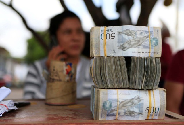 A money changer sits at a table at the border between Colombia and Venezuela, in Paraguachon, Colombia February 16, 2018. Picture taken February 16, 2018. REUTERS/Jaime Saldarriaga