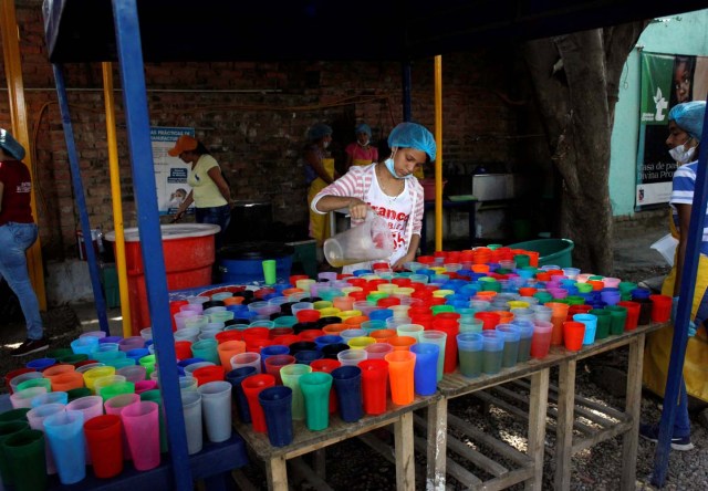 A voluntary worker fills cups with water at a dining facility organised by Caritas and the Catholic church for Venezuelans, in Cucuta, Colombia February 21, 2018. Picture taken February 21, 2018. REUTERS/Carlos Eduardo Ramirez