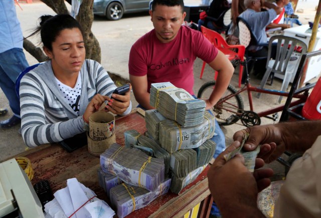A money changer uses a calculator at the border between Colombia and Venezuela, in Paraguachon, Colombia February 16, 2018. Picture taken February 16, 2018. REUTERS/Jaime Saldarriaga