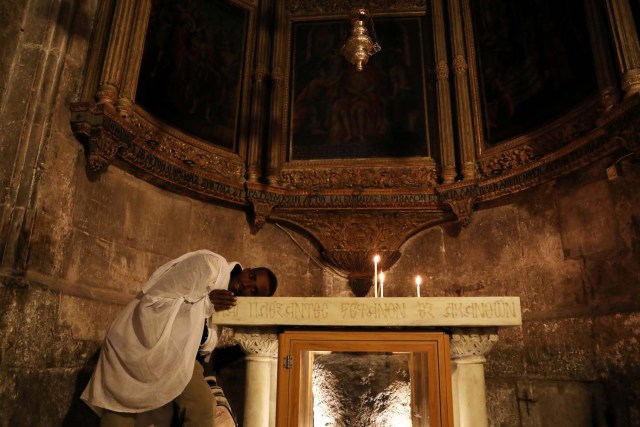 A worshipper places his head on an altar in the Church of the Holy Sepulchre in Jerusalem's Old City, February 28, 2018. REUTERS/Ammar Awad