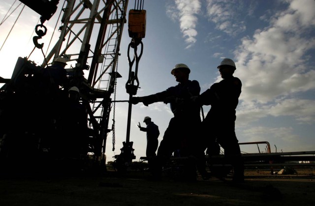 FILE PHOTO: Oil workers are seen at an oil field in Cabimas in Venezuela's western state of Zulia, near Lake Maracaibo, March 1, 2008. To match Special Report WHO-IARC/BENZENE REUTERS/Jorge Silva/File Photo