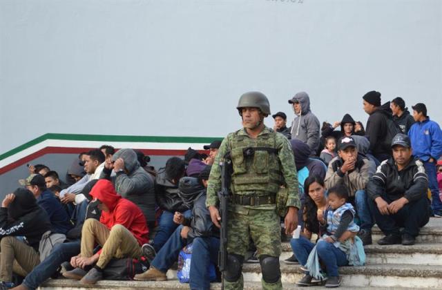 TAMAULIPAS (MÉXICO), 03/02/2018.- Un soldado resguarda a un grupo de inmigrante interceptados hoy, sábado 3 de febrero de 2018, en Tamaulipas (México). Las autoridades mexicanas rescataron a un total de 301 migrantes centroamericanos que eran transportados en precarias condiciones en los estados de Tamaulipas y Veracruz, informaron hoy autoridades migratorias. EFE/José Martínez