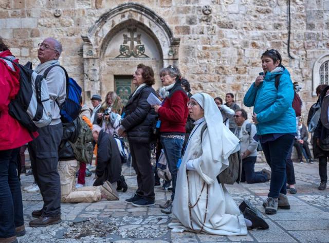 Peregrinos cristianos rezan en la puerta del Santo Sepulcro, el lugar más sagrado del cristianismo y que lleva tres días cerrado por una cuestión de impuestos municipales, en la Ciudad Vieja de Jerusalén, el 27 de febrero del 2018. EFE/Jim Hollander