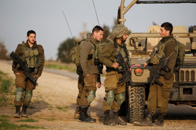 Soldados israelíes están de pie junto a un jeep militar cerca de la valla fronteriza con el sur de la Franja de Gaza, en las inmediaciones de Kibbutz Nirim, Israel. 17 de febrero, 2018. REUTERS/Amir Cohen
