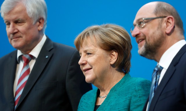 En la imagen, la líder de la CDU y canciller alemana, Angela Merkel, entre el líder de la CSU, Horst Seehofer (I) y el del socialdemócrata SPD, Martin Schulz, tras una declaración sobre las negociaciones para formar un nuevo gobierno, en Berlín, Alemania el 7 de ferbero de 2018. REUTERS/Hannibal Hanschke