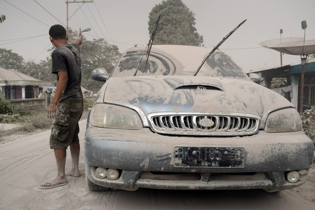 Ash from Mount Sinabung volcano covers a car and street following an eruption in Karo, North Sumatra, Indonesia February 19, 2018 in this photo taken by Antara Foto.  Antara Foto/ Surianto Sembiring / via REUTERS  ATTENTION EDITORS - THIS IMAGE WAS PROVIDED BY A THIRD PARTY. MANDATORY CREDIT. INDONESIA OUT. NO COMMERCIAL OR EDITORIAL SALES IN INDONESIA.