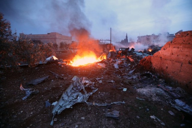 A picture taken on February 3, 2018, shows fire fighters battling the flames at the site of a downed Sukhoi-25 fighter jet near the Syrian city of Saraqib, southwest of Aleppo. Rebel fighters shot down a Russian plane over Syria's northwest Idlib province and captured its pilot, the Syrian Observatory for Human Rights said. / AFP PHOTO / OMAR HAJ KADOUR