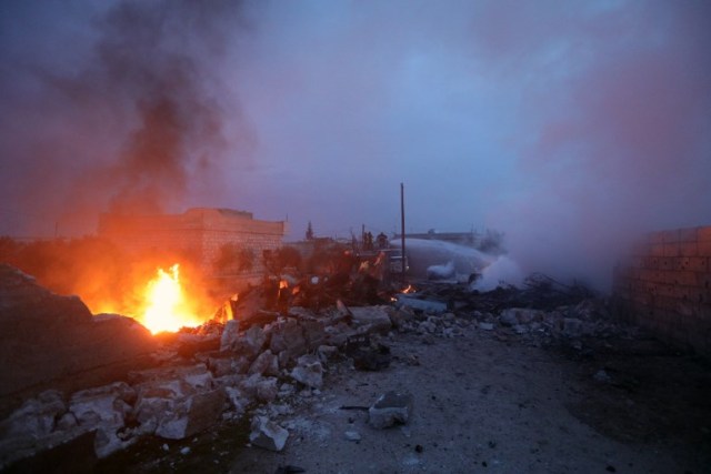 A picture taken on February 3, 2018, shows fire fighters battling the flames at the site of a downed Sukhoi-25 fighter jet near the Syrian city of Saraqib, southwest of Aleppo. Rebel fighters shot down a Russian plane over Syria's northwest Idlib province and captured its pilot, the Syrian Observatory for Human Rights said. / AFP PHOTO / OMAR HAJ KADOUR
