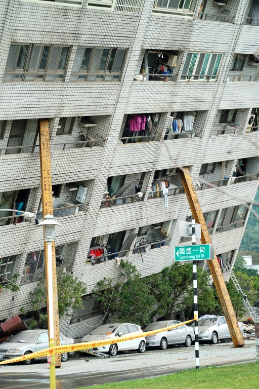 Las vigas de soporte ayudan a apuntalar un edificio que salió de su cimiento, la mañana después de que un terremoto de magnitud 6,4 golpeara la ciudad taiwanesa oriental de Hualien, el 7 de febrero de 2018. / AFP PHOTO / PAUL YANG
