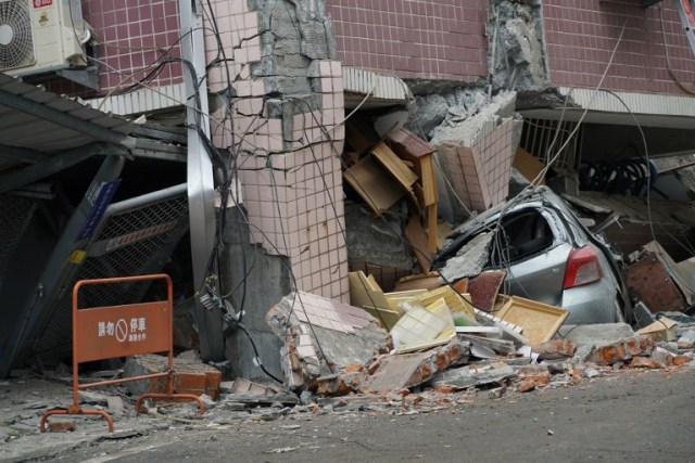 Un automóvil se encuentra aplastado por un edificio que salió de su cúspide luego de que un terremoto de 6,4 grados de magnitud golpeara la ciudad taiwanesa oriental de Hualien, el 7 de febrero de 2018. / AFP PHOTO / PAUL YANG