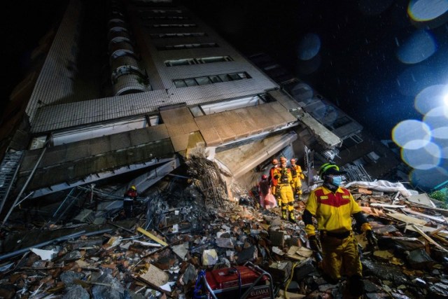 Los equipos de rescate caminan sobre una pila de escombros del edificio Yun Tsui después de un terremoto en la ciudad taiwanesa de Hualien el 7 de febrero de 2018. / AFP PHOTO / Anthony WALLACE