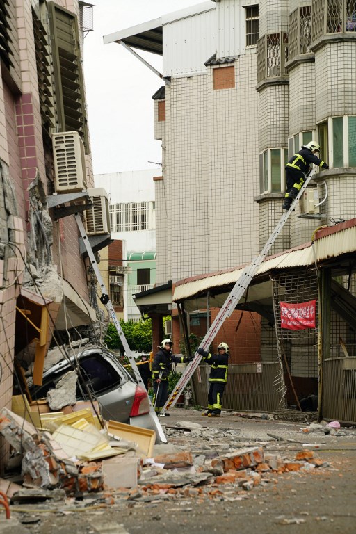 Los trabajadores de rescate y emergencia revisan a los sobrevivientes dentro de un edificio dañado, la mañana después de que un terremoto de 6,4 grados de magnitud afectara la ciudad taiwanesa oriental de Hualien, el 7 de febrero de 2018. / AFP PHOTO / PAUL YANG